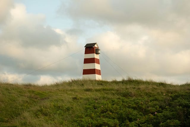 landscape photo of a lighthouse in a field
